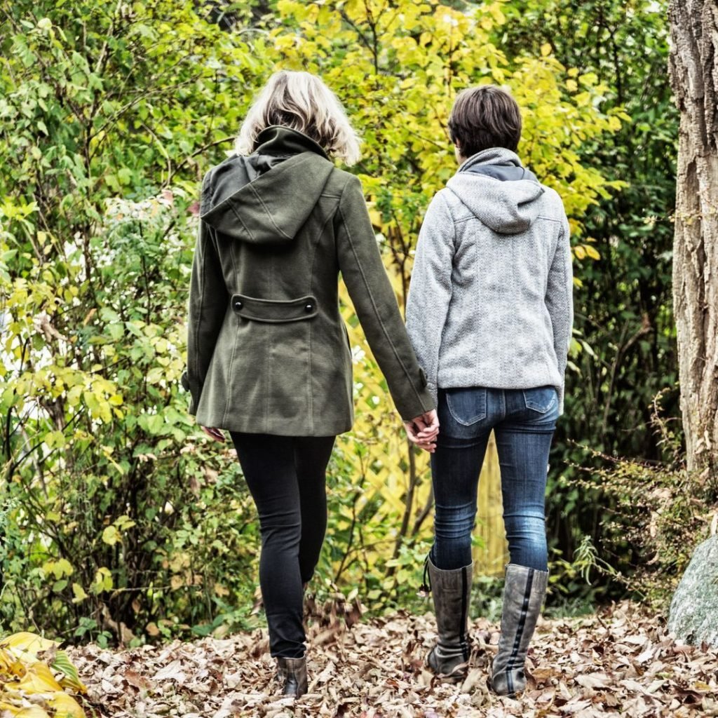 Mum and teenage child walking through the woods in their winter coats