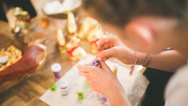 The picture shows someone at a table crafting. Behind them is a golden glow.