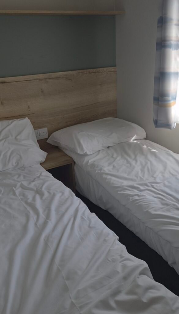 The photo shows two small single beds, both have fresh clean linen. They are extremely close together and the room is very small but clean