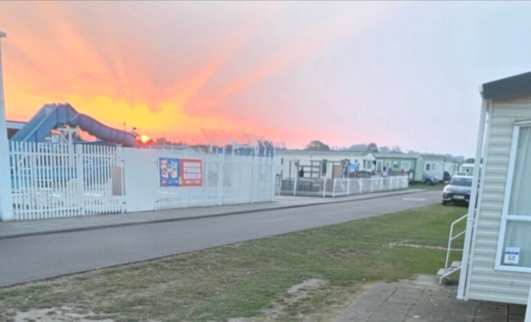 The photo shows a sunset over the water slide at the outdoor pool